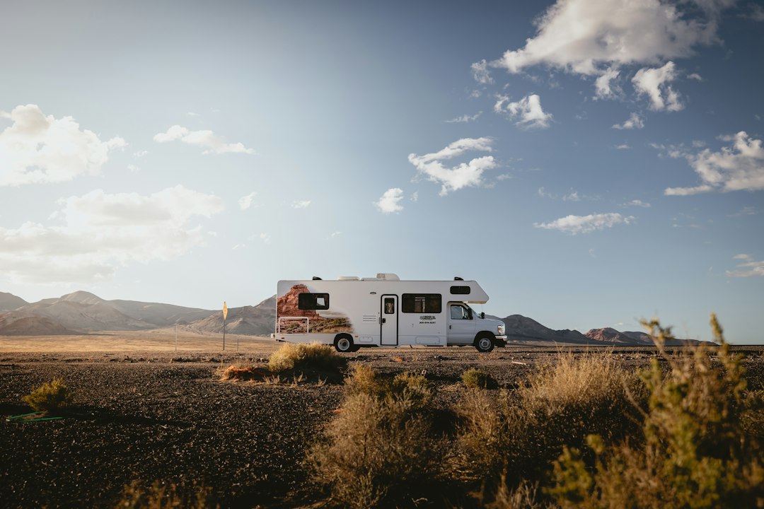 A white rv travels down a desert highway